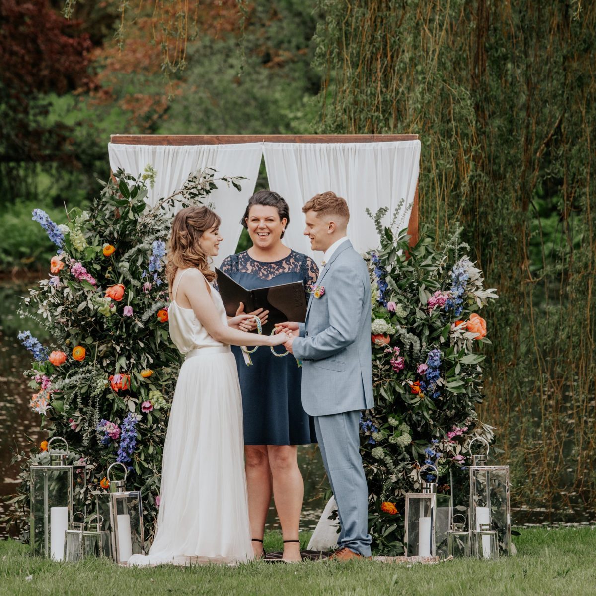 A bride and groom holding a braided rope during their outdoor wedding ceremony at Wooladon Estate