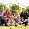 Devon Wedding Venue, Wooladon Estate owners in the Strawberry Fields Farm shop tunnels with children Lily and Thomas with punnets of strawberries.